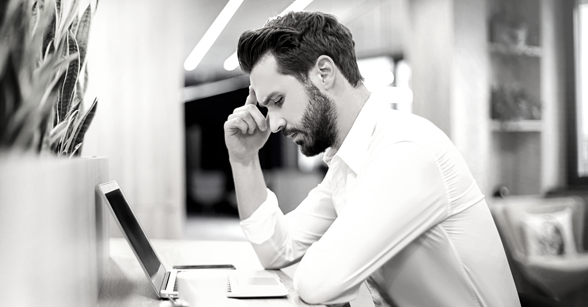 Man sat at laptop after being made redundant